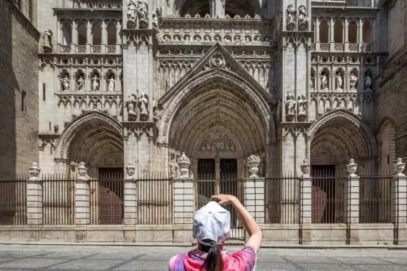 A tourist in front of the Cathedral of Toledo